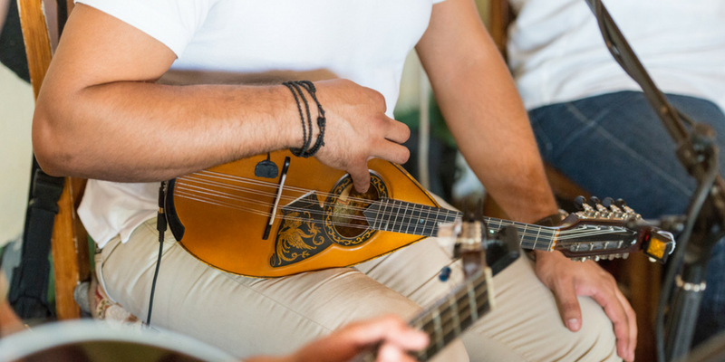 man with mandolin tuning a mandolin in mandolin lesson