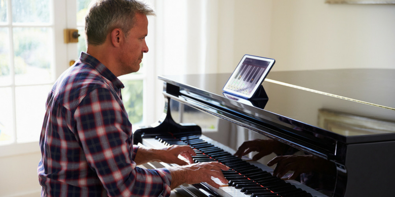 man playing piano and taking piano lessons